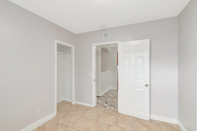 unfurnished bedroom with baseboards, visible vents, and a closet