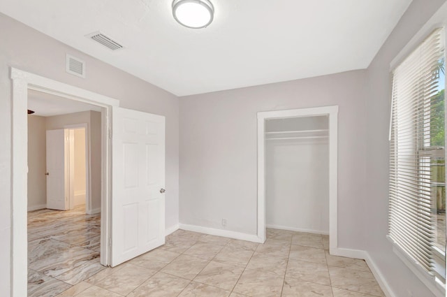 unfurnished bedroom featuring a closet, visible vents, and baseboards