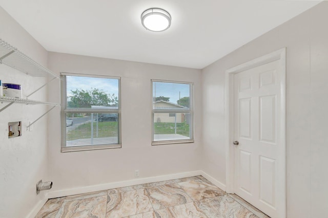 spare room with marble finish floor and baseboards