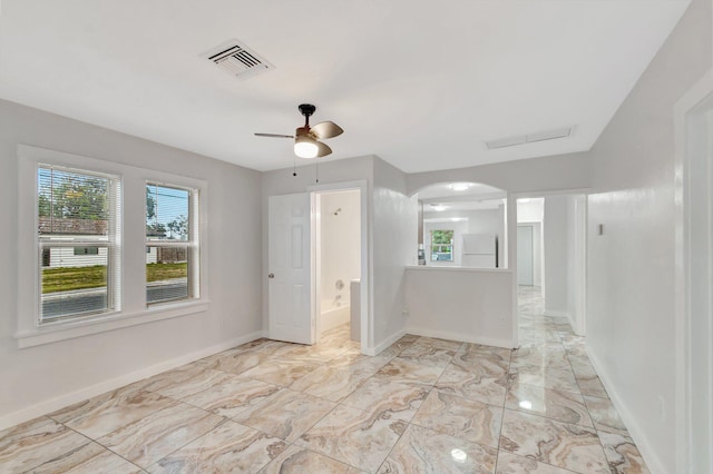 unfurnished room with a healthy amount of sunlight, visible vents, marble finish floor, and baseboards