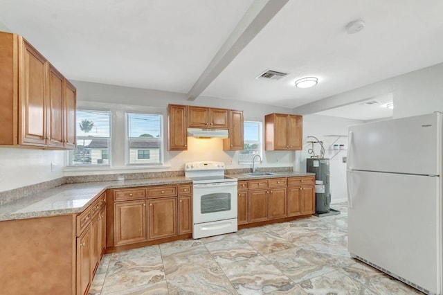 kitchen featuring white appliances, visible vents, under cabinet range hood, water heater, and a sink