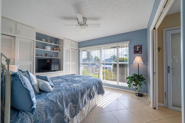 bedroom with light tile patterned floors, a textured ceiling, visible vents, and baseboards