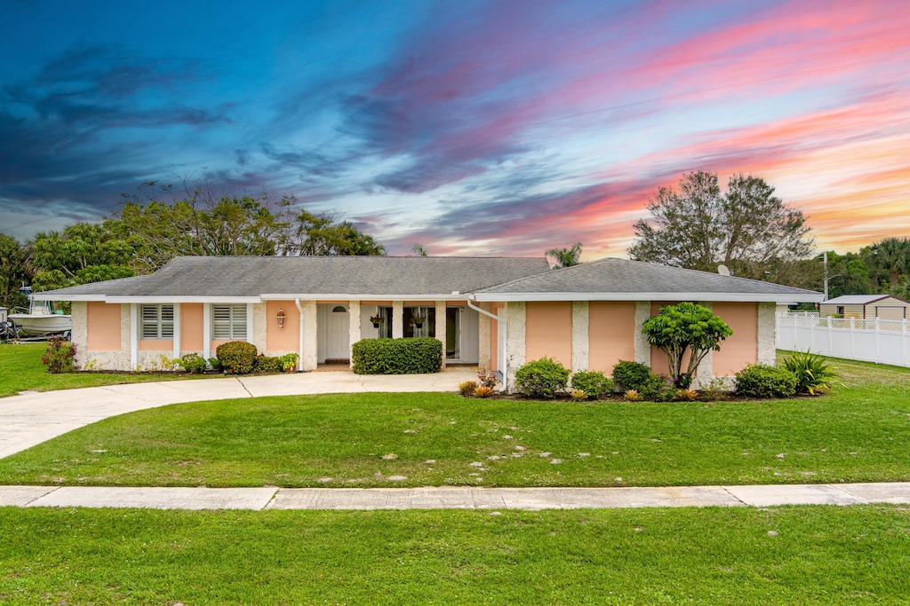 single story home with a lawn