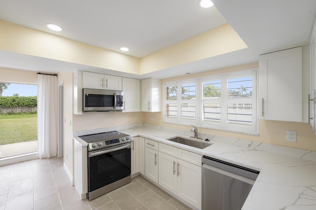 kitchen featuring sink, stainless steel appliances, light stone countertops, and white cabinets