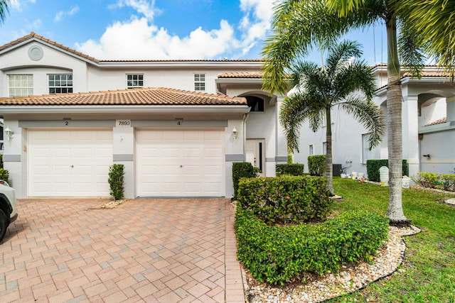 mediterranean / spanish-style house with a garage and central AC