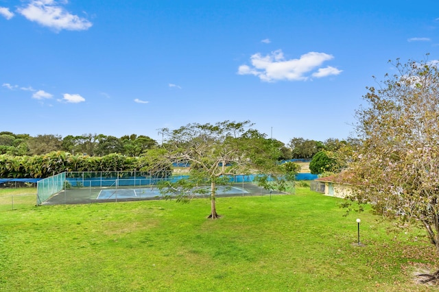 view of yard with a water view and tennis court