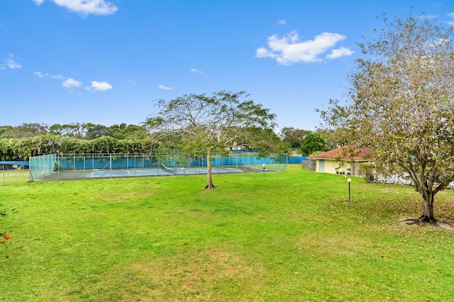 view of yard with tennis court and a water view