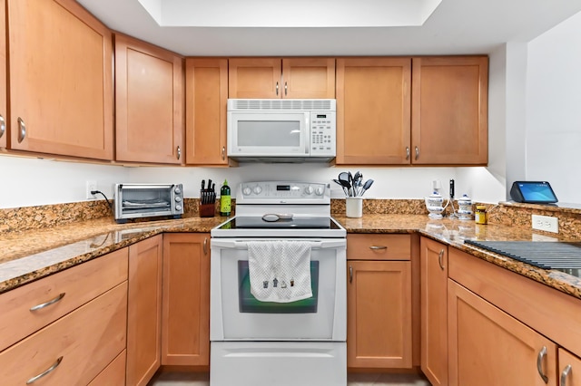 kitchen featuring white appliances and light stone countertops