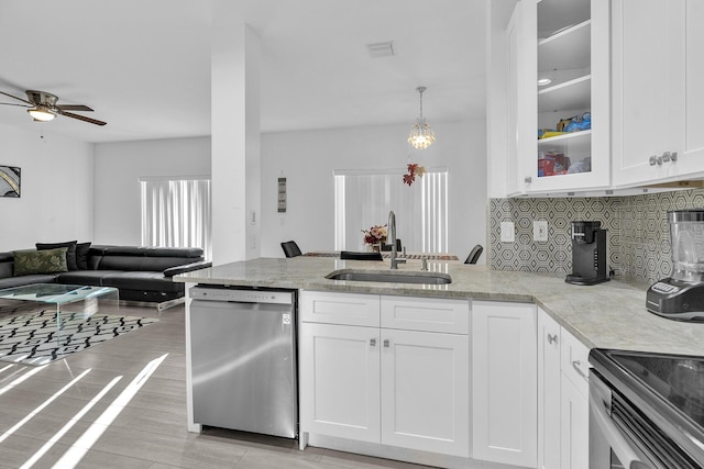 kitchen featuring light stone counters, sink, stainless steel appliances, and white cabinets