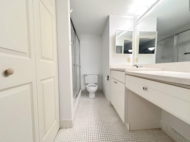 bathroom with vanity, tile patterned floors, toilet, and walk in shower