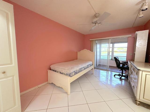 bedroom with rail lighting, light tile patterned floors, access to exterior, and ceiling fan