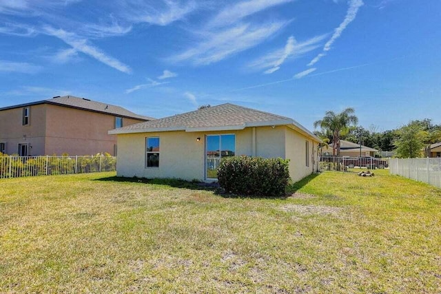 rear view of house featuring a lawn