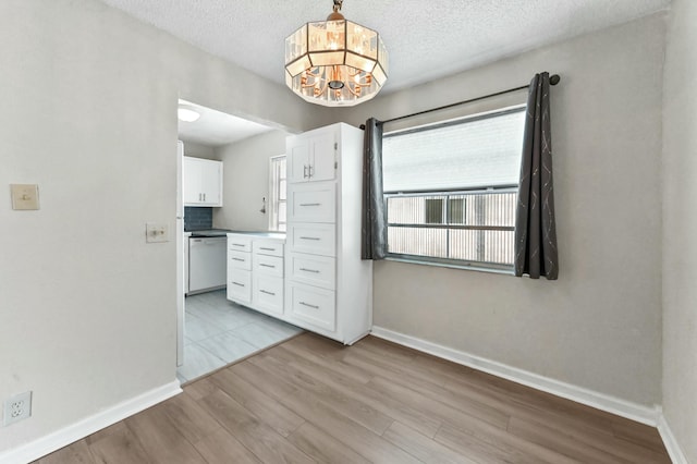 364 Capri H, Delray Beach, FL 33484 - unfurnished dining area with light wood-type flooring and a textured ceiling