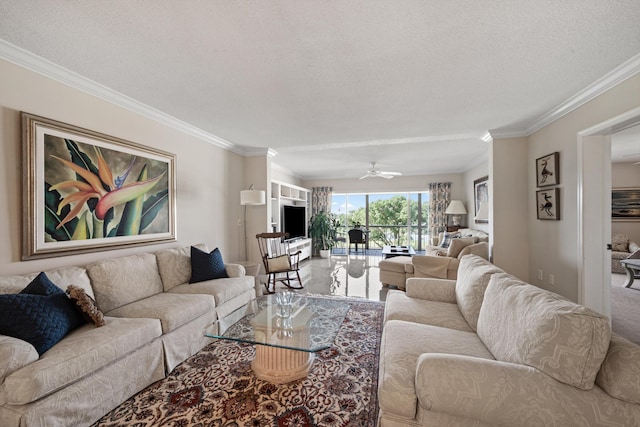living room with ceiling fan, ornamental molding, and a textured ceiling