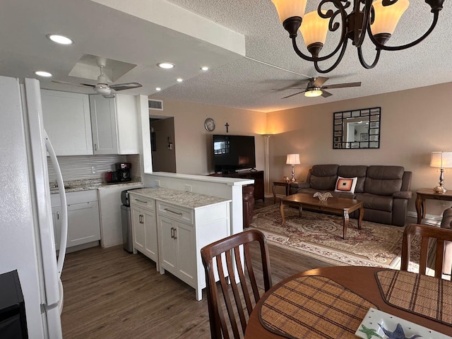 kitchen featuring white fridge, white cabinetry, dark hardwood / wood-style floors, ceiling fan, and kitchen peninsula