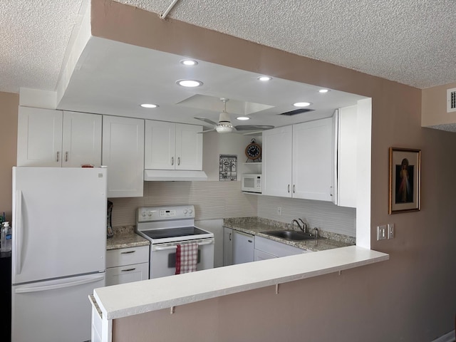 kitchen featuring white appliances, white cabinetry, sink, and kitchen peninsula