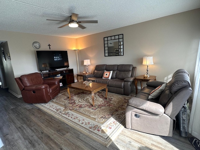 living room with a textured ceiling, dark wood-type flooring, and ceiling fan