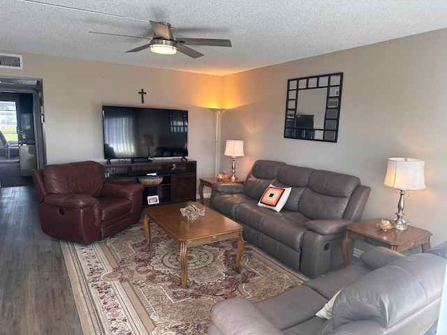 living room featuring hardwood / wood-style flooring, ceiling fan, and a textured ceiling