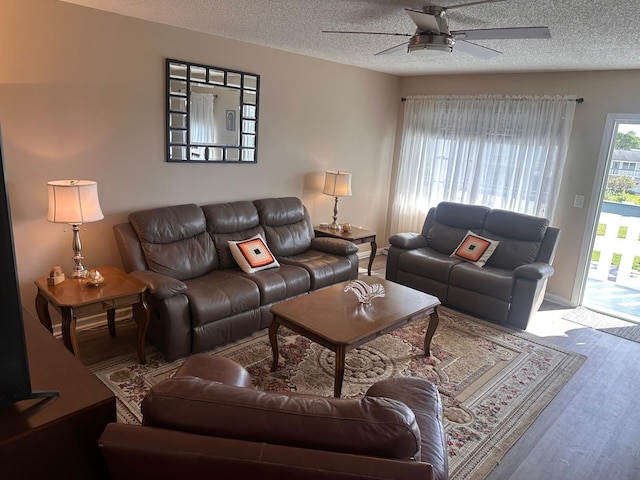 living room featuring a textured ceiling and ceiling fan