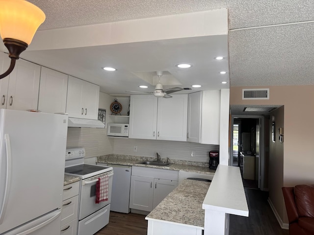 kitchen featuring white appliances, white cabinets, a kitchen island, sink, and dark hardwood / wood-style floors