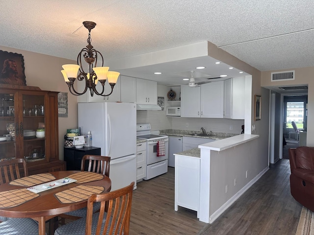 kitchen with white appliances, sink, white cabinets, kitchen peninsula, and hanging light fixtures