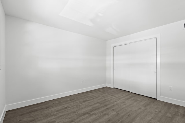 unfurnished bedroom featuring a closet and dark hardwood / wood-style flooring