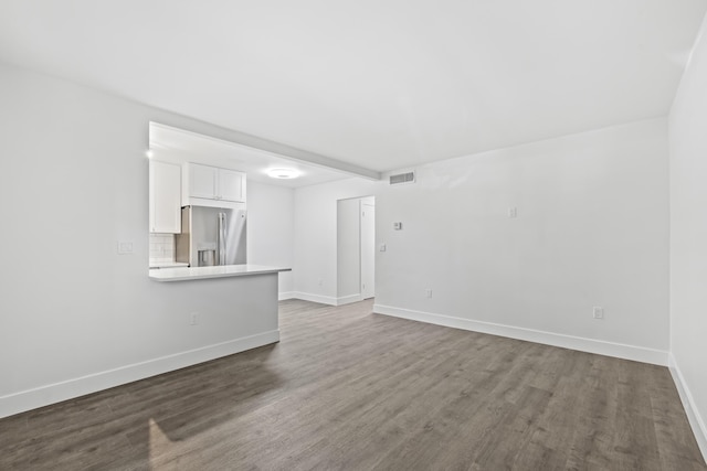 unfurnished living room with dark hardwood / wood-style flooring and beamed ceiling