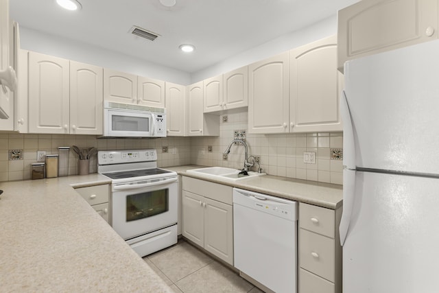 kitchen featuring light countertops, visible vents, white cabinetry, a sink, and white appliances