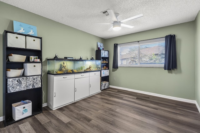 kitchen with dark wood-style flooring, dark countertops, white cabinetry, ceiling fan, and a textured ceiling