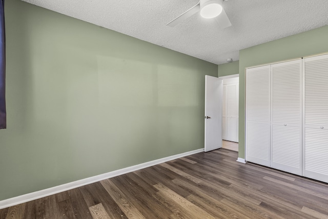 unfurnished bedroom with baseboards, ceiling fan, wood finished floors, a textured ceiling, and a closet