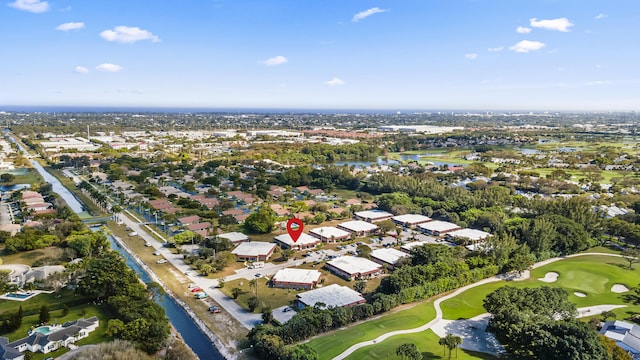 drone / aerial view featuring golf course view, a water view, and a residential view