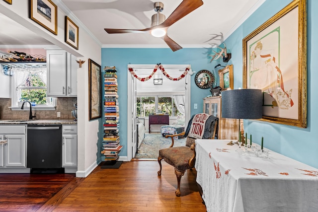 interior space with ceiling fan, ornamental molding, wet bar, and dark hardwood / wood-style flooring