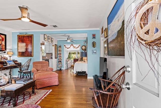 living area featuring ceiling fan, ornamental molding, and dark hardwood / wood-style floors