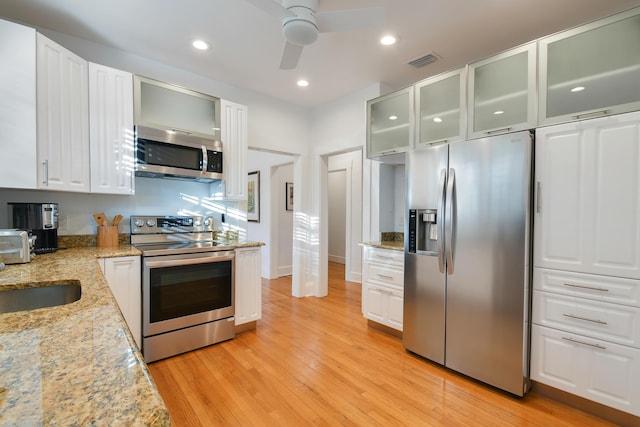 kitchen with white cabinetry, light wood-style floors, visible vents, a ceiling fan, and appliances with stainless steel finishes
