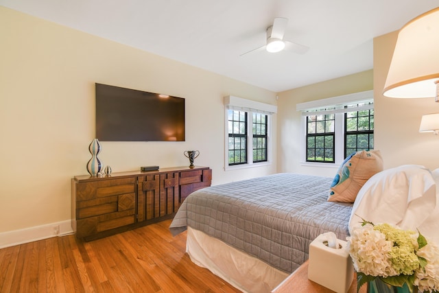 bedroom featuring a ceiling fan, baseboards, and wood finished floors