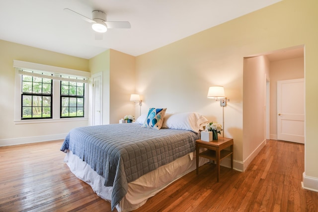 bedroom with baseboards, wood finished floors, and a ceiling fan