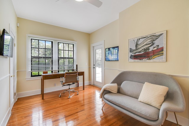 home office with baseboards, ceiling fan, and light wood-style flooring