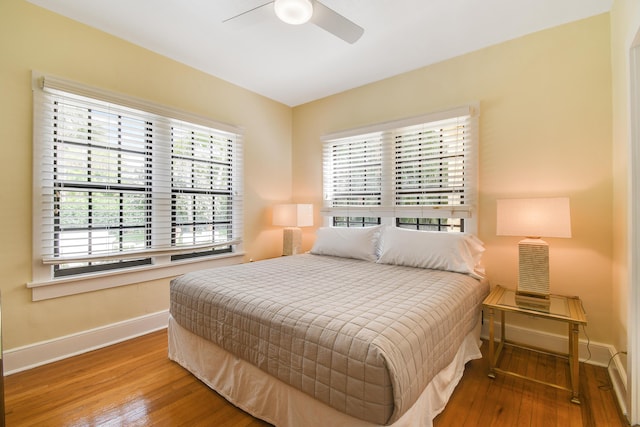 bedroom featuring wood-type flooring, baseboards, and ceiling fan