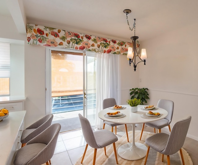 dining area with light tile patterned flooring and a notable chandelier