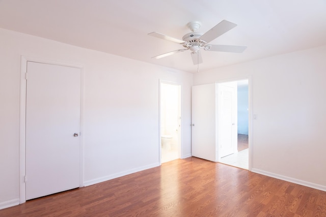 spare room with baseboards, a ceiling fan, and wood finished floors