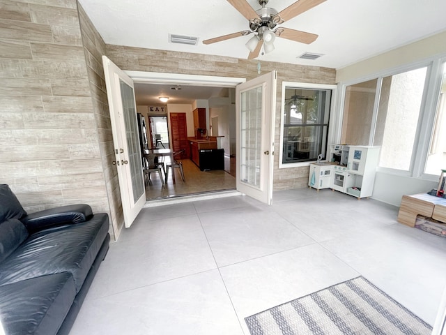 tiled living room with french doors and ceiling fan