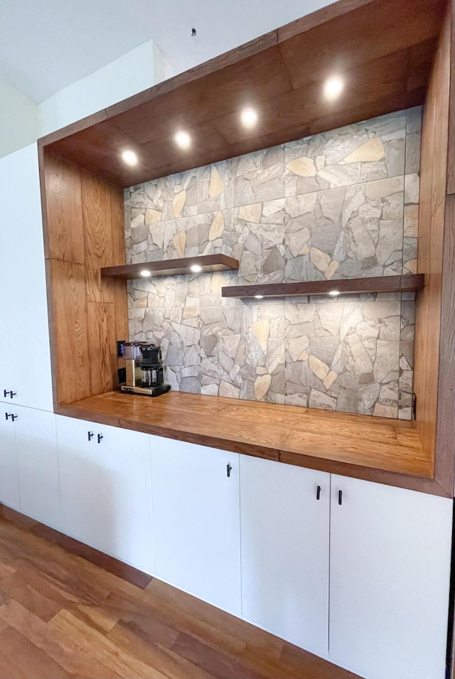 interior space with butcher block counters, light hardwood / wood-style floors, and white cabinets