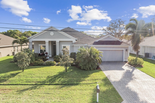 view of front of property with a garage, central AC, a front yard, and a porch