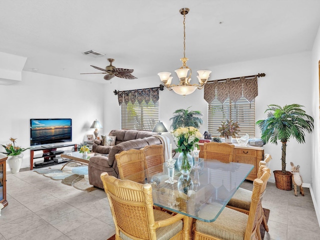 tiled dining space with ceiling fan with notable chandelier