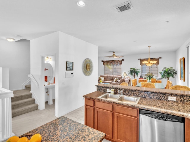 kitchen featuring ceiling fan with notable chandelier, sink, hanging light fixtures, stainless steel dishwasher, and light tile patterned floors