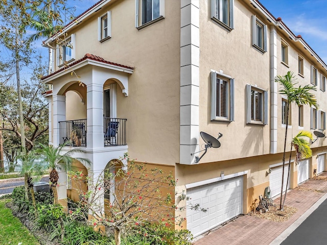 view of property exterior featuring a balcony and a garage