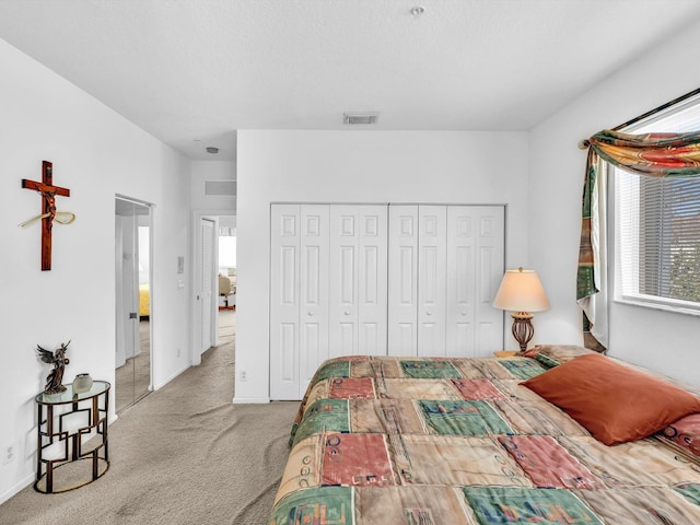 carpeted bedroom featuring a textured ceiling and a closet