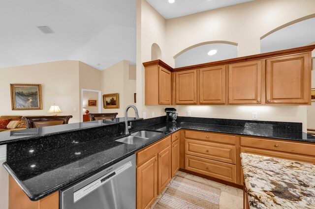 kitchen with sink, kitchen peninsula, vaulted ceiling, stainless steel dishwasher, and dark stone counters