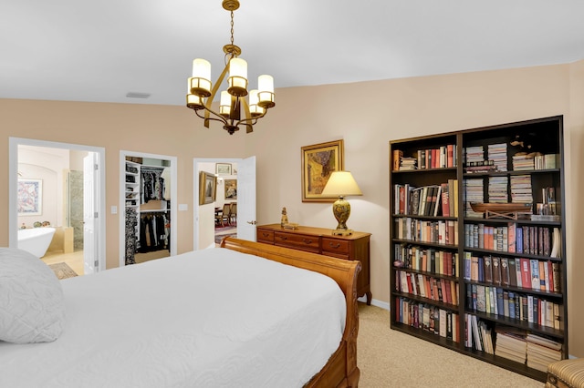 carpeted bedroom featuring vaulted ceiling, a spacious closet, a notable chandelier, ensuite bath, and a closet