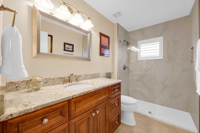 bathroom featuring vanity, a shower with shower door, and toilet